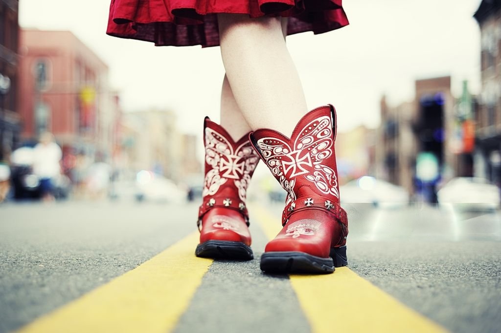 Red Western cowboy boots on city street.