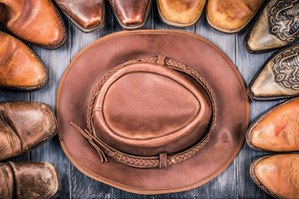 Leather cowboy hat and boots symbolizing Boot N Shoot western franchise.