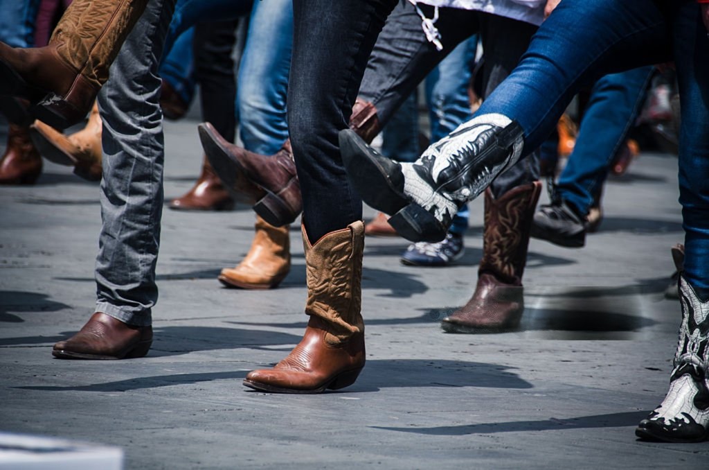 People wearing western cowboy boots walking together, showcasing casual western fashion style.